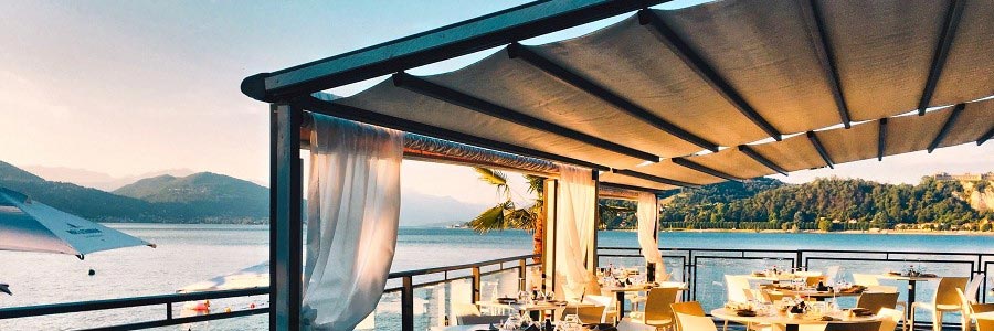 Moderne windstabile Markisen über einer Restaurant-Terrasse am Meer