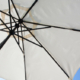 Sonnenschirm mit weißer Bespannung und Mast aus dunkelbraunem Holz